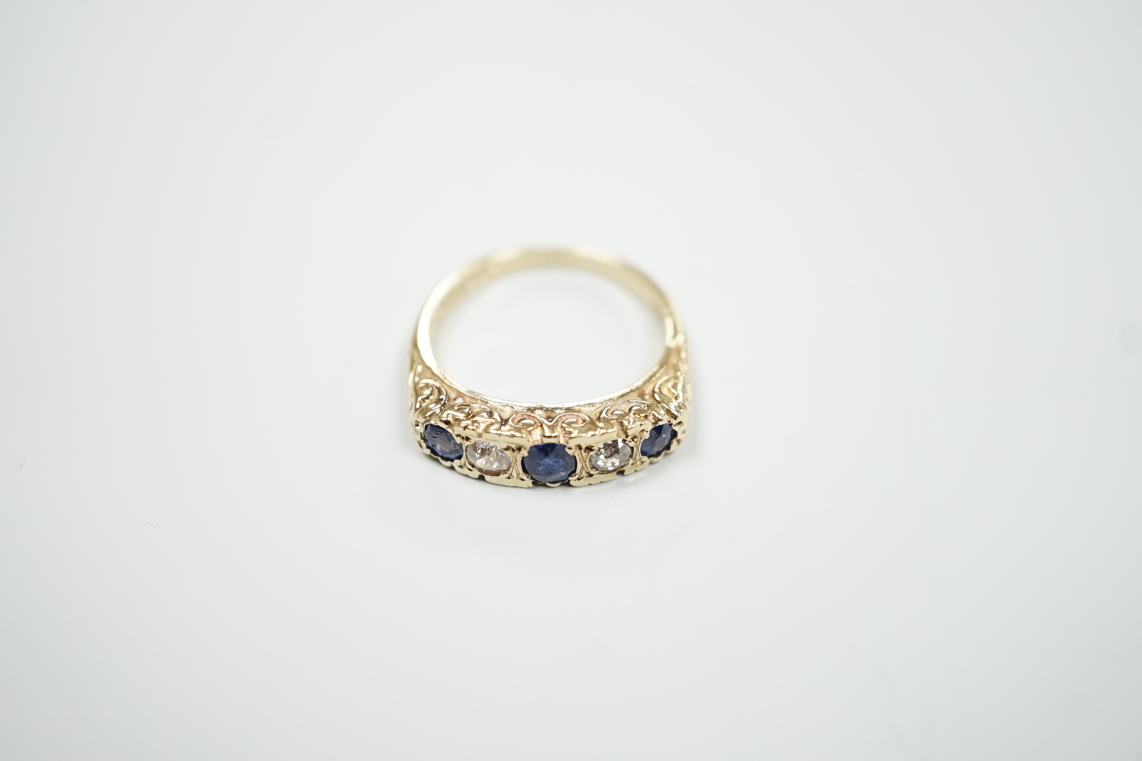 A modern Victorian style 9ct gold, three stone sapphire and two stone diamond set half hoop ring, size O, gross weight 4.3 grams.